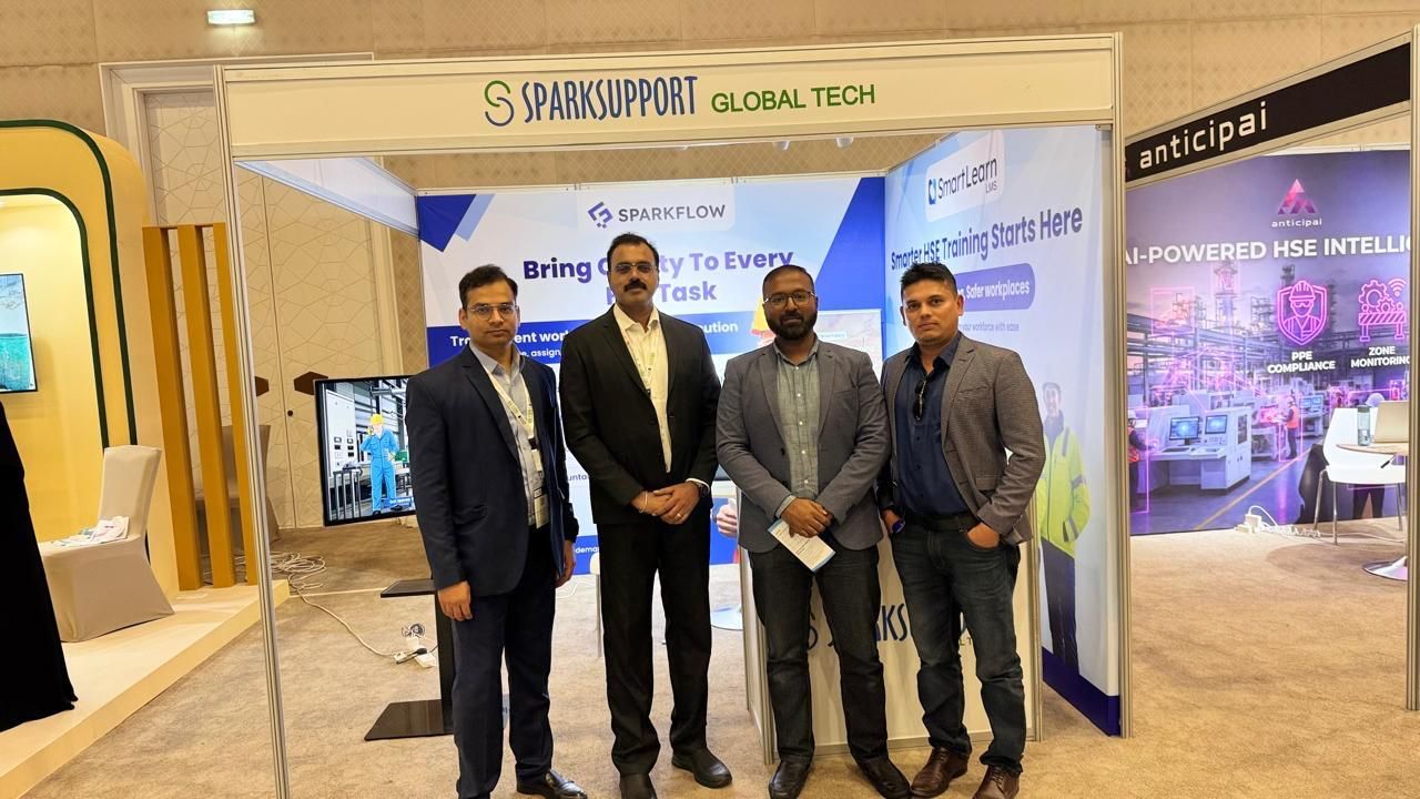 SparkSupport team photo in front of the SmartLearn LMS and SparkFlow booth