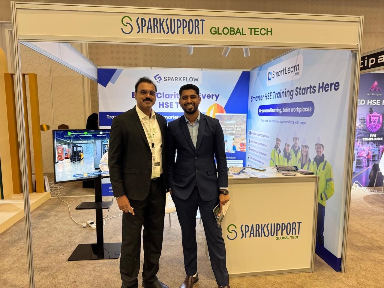 Team members speaking with visitors at the SmartLearn LMS exhibition booth